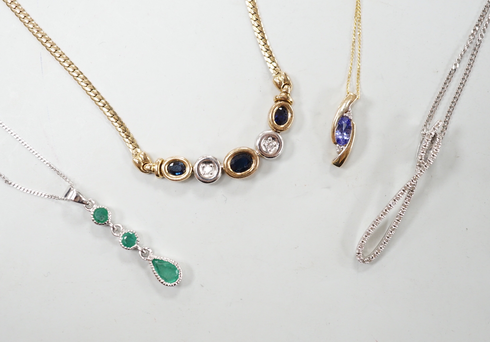 Four assorted modern 375 and gem set pendant necklaces, including white 375 and diamond chip set, 50cm and white 375 and emerald drop set, gross weight 11.3 grams.